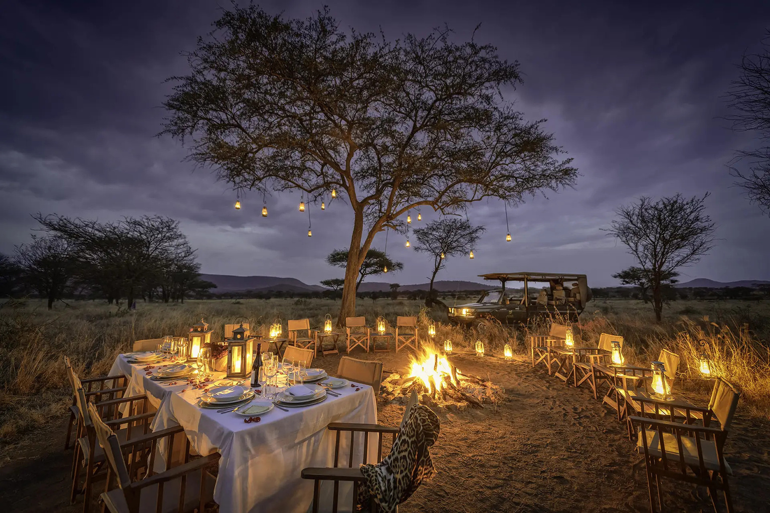 A bush dinner at night with lanterns.