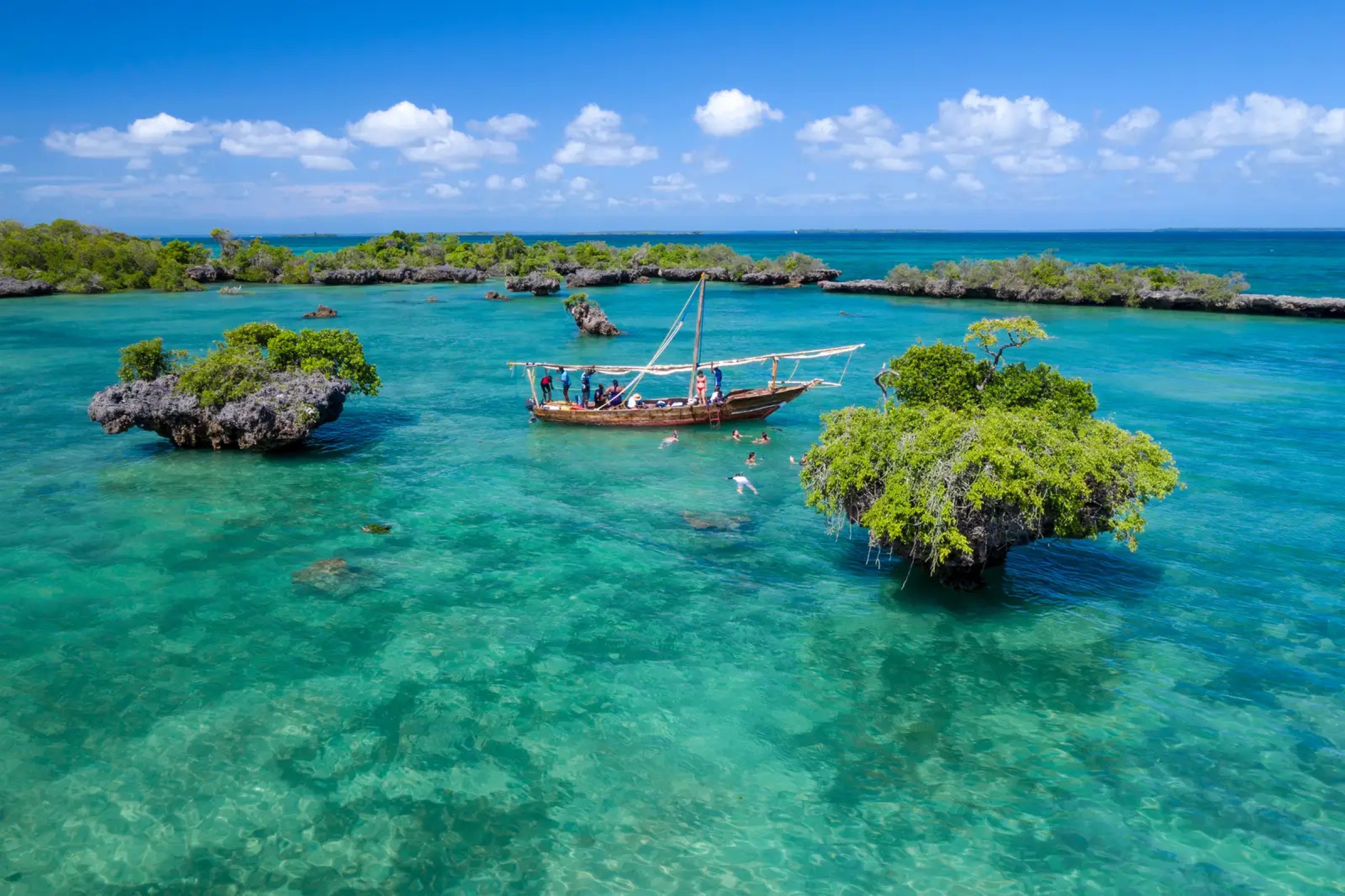 A dhow with snorkellers anchored in the turquoise water off Zanzibar.